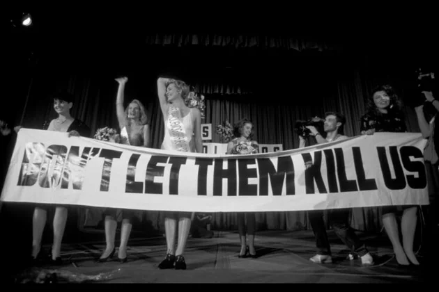 Teilnehmerinnen eines Schönheitswettbewerbs halten ein Banner mit der Aufschrift 