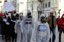 eople in protective suits and with masks on their faces can be seen in the main town square. Protest walk along the Promenade of a group of citizens opposing measures taken by the Government and the Crisis Staff to combat the COVID pandemic 19., in Rijeka, Croatia, on December 12, 2020