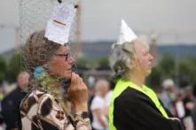 Participants take part in a demonstration against Coronavirus restrictions in Stuttgart, Germany on May 9, 2020. Similar protests and actions are being held worldwide with people asking for freedom of movement and religious ceremonies. One Person is wearing an aluminium hat, another is wearing a metal net around her head with the constiution on it.