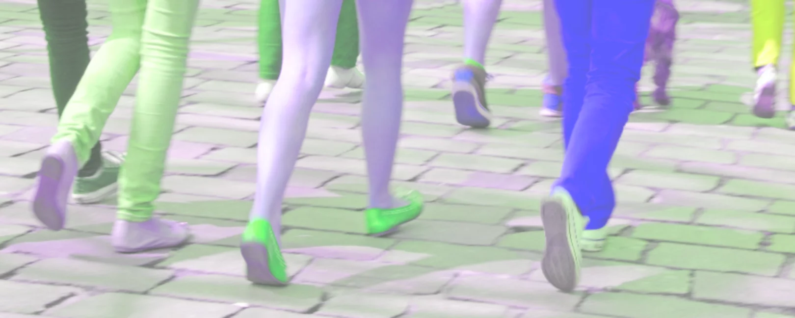 Viele verschiedene Beinpaare, die auf einer Straße laufen
