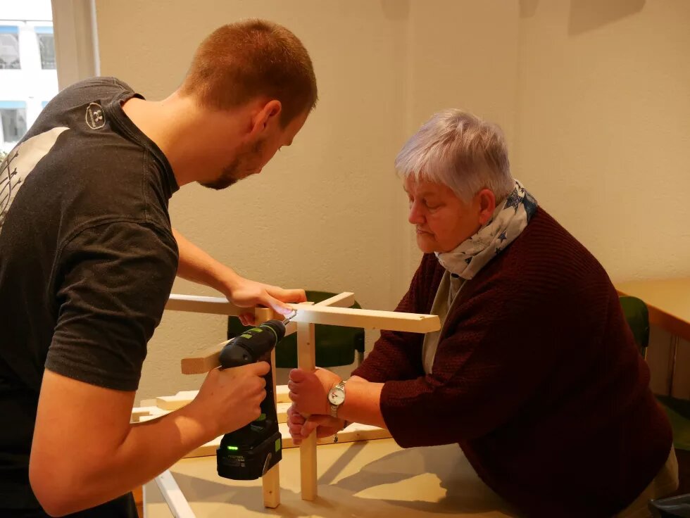 Gemeinsames Möbelbauen Zwei Personen bauen einen Tisch