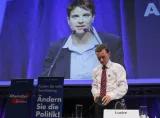 Frauke Petry appears on a large screen after being elected as leader of the eurosceptic party Alternative fuer Deutschland (AfD) while former leader Bernd Lucke wathces at the AfD's party congress in Essen, western Germany, July 4, 2015. REUTERS/Wolfgang Rattay