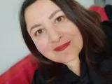 DieAutorin Eine Frau mit schulterlangen braunen Haaren schaut lächelnd in die Kamera
